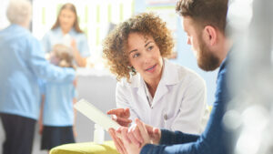 Pharmacienne qui accompagne un client à la Pharmacie Cantonale